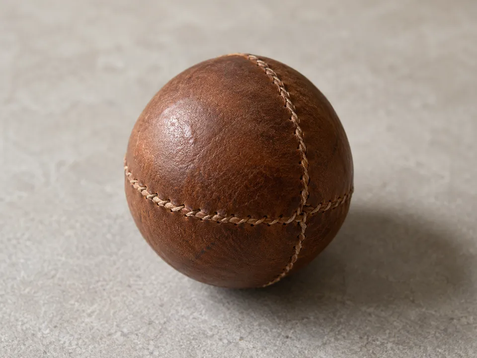 AI-generated illustration: A small brown leather ball for Valencian pilota.