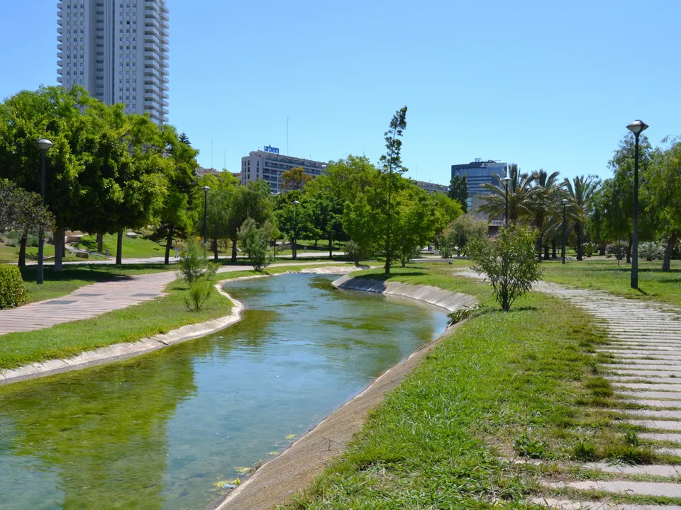 Landscaped stream, lawns and trees in Jardín del Turia, Valencia.